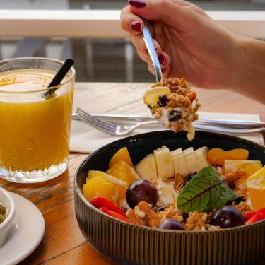 Enjoy a nutritious breakfast with fruit, nuts, and juice in a calm setting in İzmir, Türkiye.